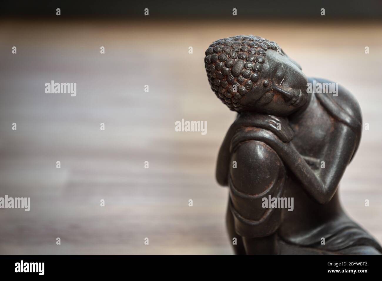 Scultura Buddha sulla scrivania - statua in miniatura buddha sulla scrivania - immagine concettuale per mediazione, consapevolezza, relax, filosofia Foto Stock