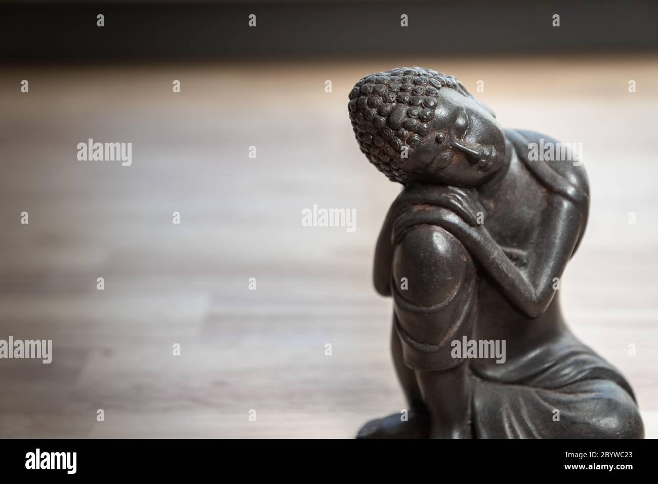 Scultura Buddha sulla scrivania - statua in miniatura buddha sulla scrivania - immagine concettuale per mediazione, consapevolezza, relax, filosofia Foto Stock