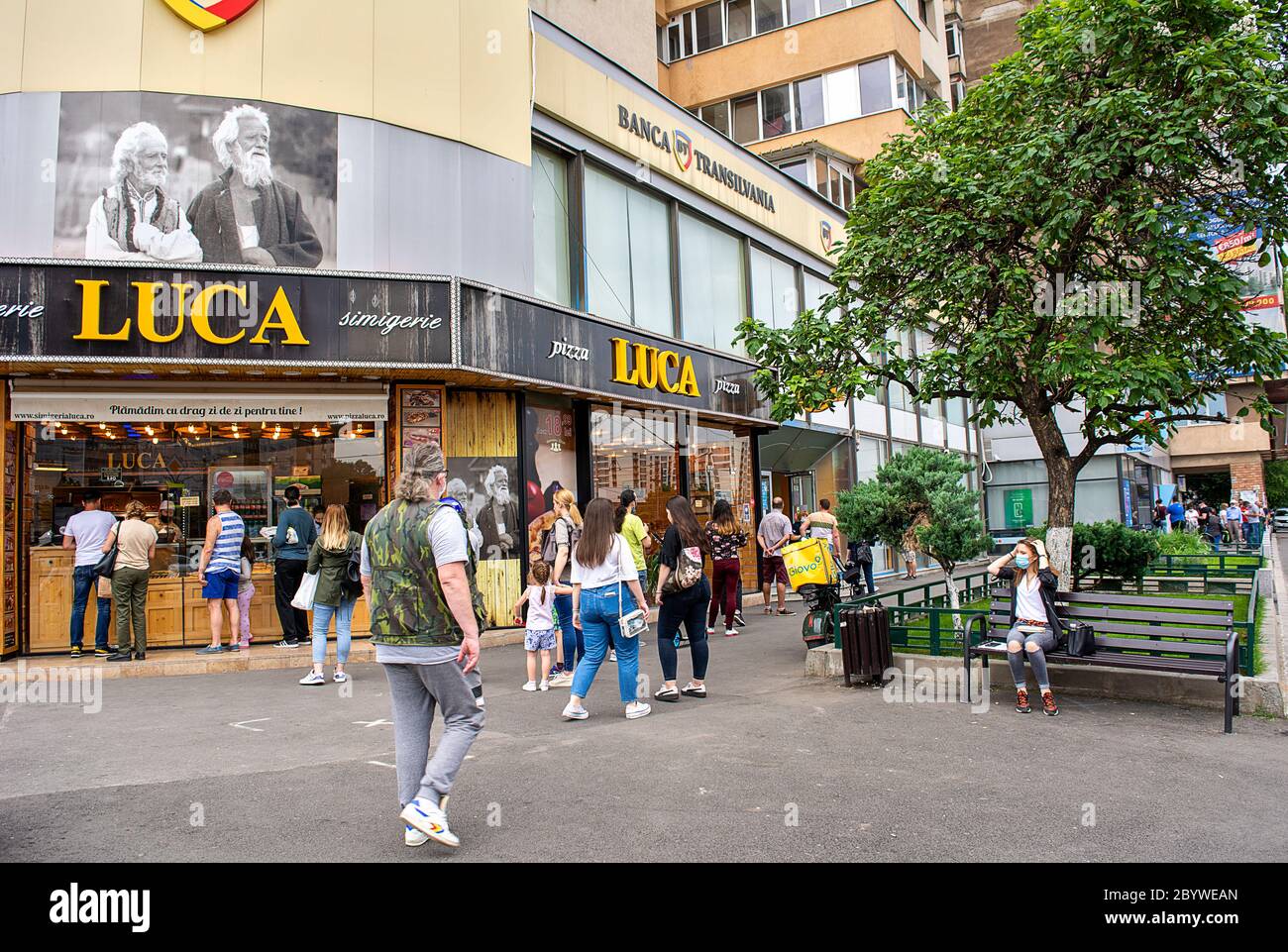 10 giugno 2020 - Bucarest, Romania. Persone in attesa di fila per entrare nella banca 'Banca Transilvania' e mantenere una distanza sociale, ma non weari Foto Stock