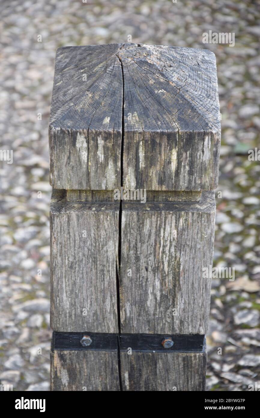Palo di legno incrinato su pavimento in pietra Foto Stock