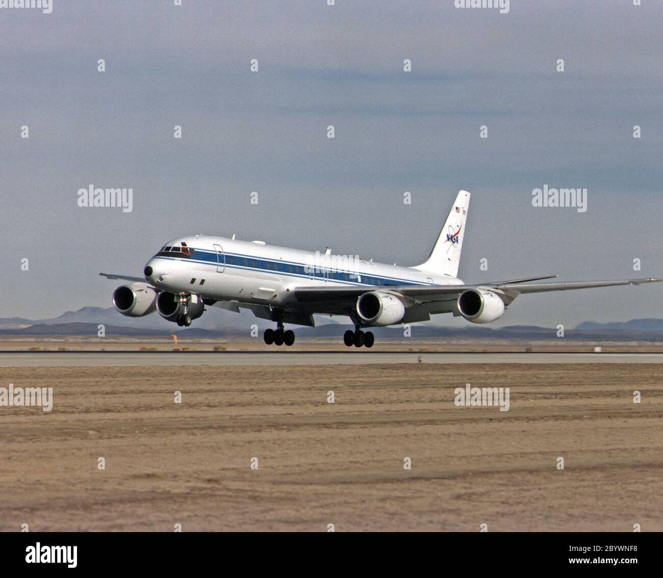 La piattaforma della NASA DC-8 Airborne Science è atterrata alla base dell'aeronautica di Edwards, California, per unirsi alla flotta di aeromobili presso il Dryden Flight Research Center della NASA. L'aereo bianco con una striscia blu che corre orizzontalmente dal naso alla coda è mostrato con il suo equipaggiamento di atterraggio principale appena sopra la pista. L'ex aereo di linea è un modello '72' e ha una portata di 5,400 miglia. L'imbarcazione può rimanere in volo per 12 ore e ha una gamma di velocità operativa compresa tra 300 e 500 nodi. I voli di ricerca sono effettuati tra i 500 e i 41,000 piedi. L'aeromobile può trasportare fino a 30,000 libbre di ricerca/scienza paga Foto Stock