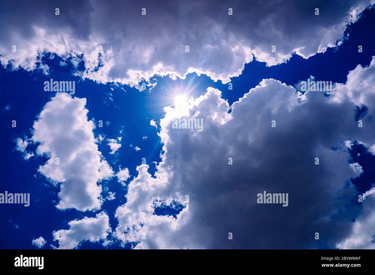 Il sole sorge tra le nubi di tempesta bluastre ispirate alla divina. Foto Stock