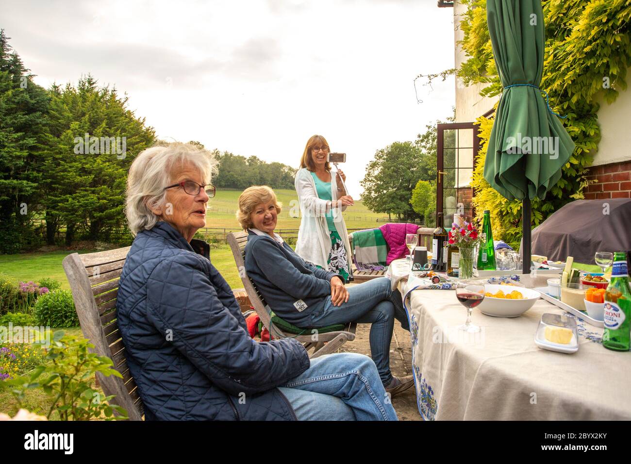 Riunione di club di libri di divaricamento sociale nel giardino dei soci nel Regno Unito Foto Stock