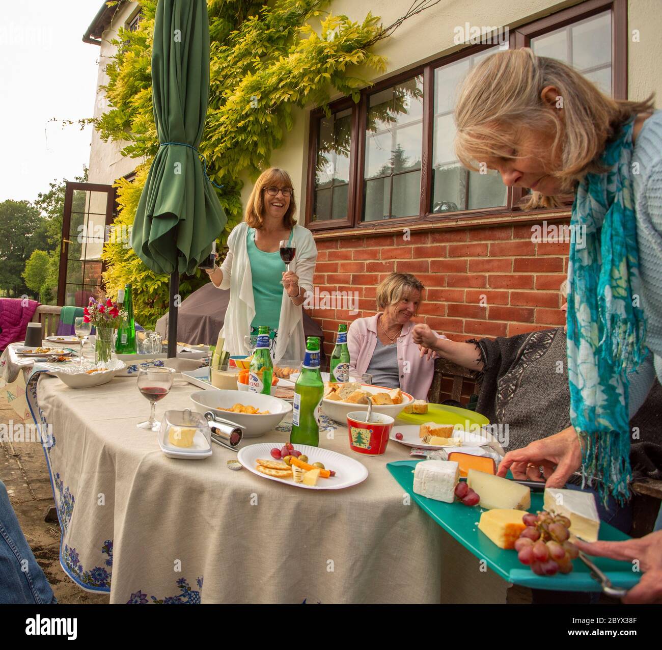 Riunione di club di libri di divaricamento sociale nel giardino dei soci nel Regno Unito Foto Stock