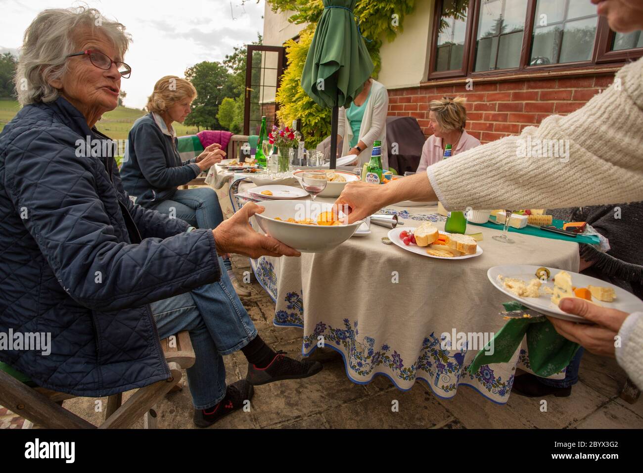 Riunione di club di libri di divaricamento sociale nel giardino dei soci nel Regno Unito Foto Stock