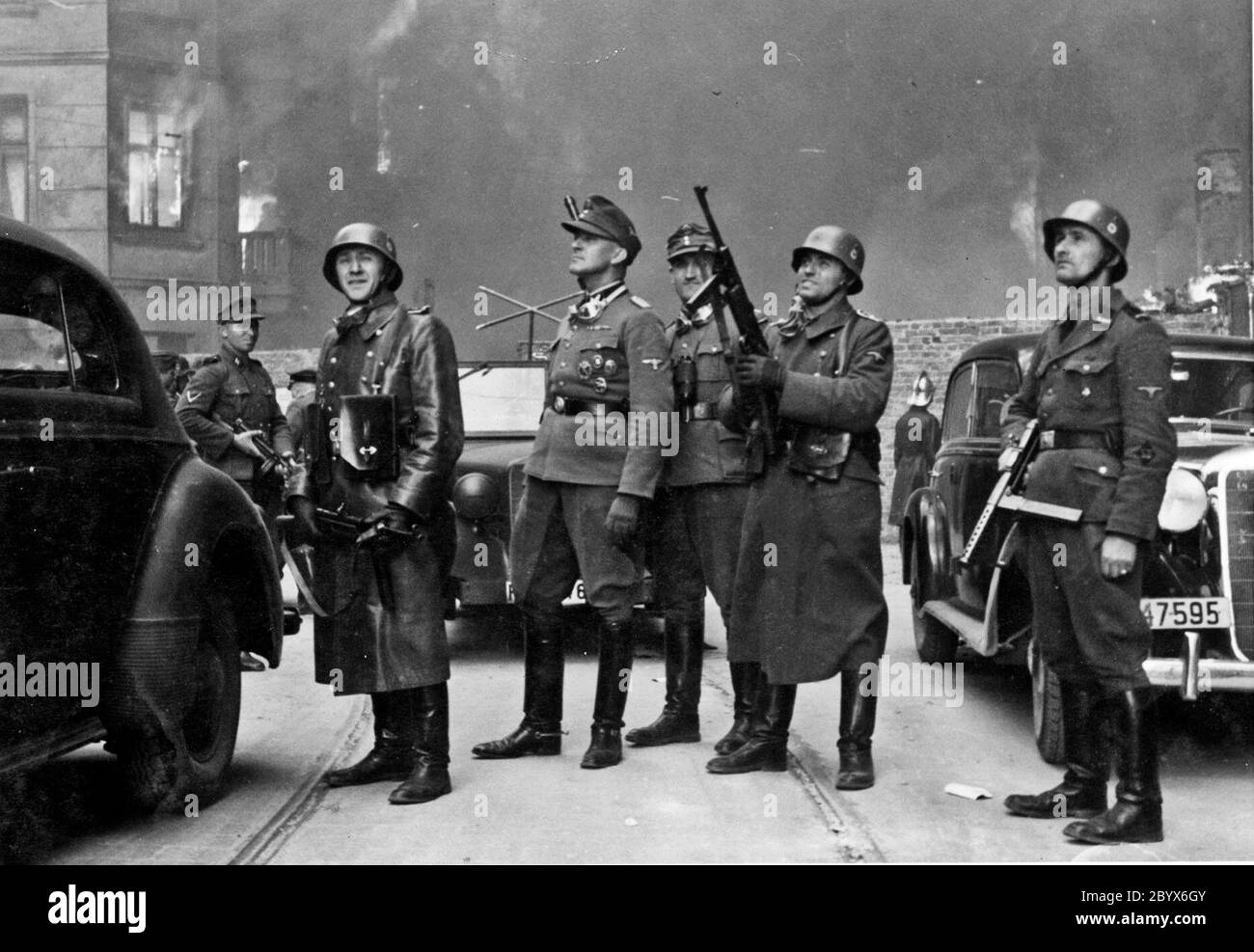 Blösche a destra, accanto a lui è Heinrich Klaustermeyer, a sinistra è Karl Kaleske o Erich Steidtmann con Jürgen Stroop a sinistra guardando blocchi di alloggi bruciare durante la rivolta del ghetto di Varsavia. Foto scattata in via Nowolipie guardando est, vicino all'incrocio con via Smocza. Sul balcone di sinistra della casa cittadina Nowolibie 66. Foto Stock