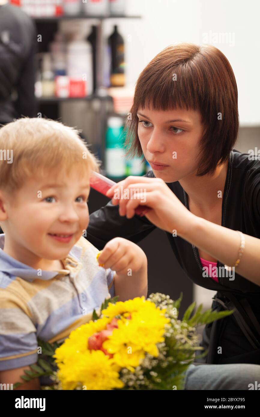 Ragazzo giovane getting taglio di capelli da styist Foto Stock