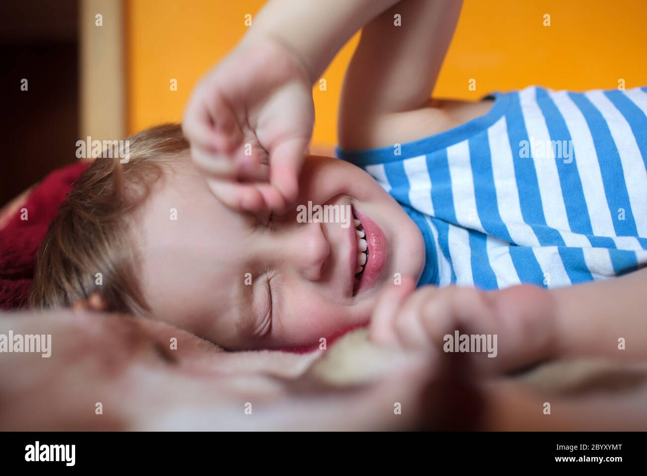 Ragazzo assonnato sul letto Foto Stock