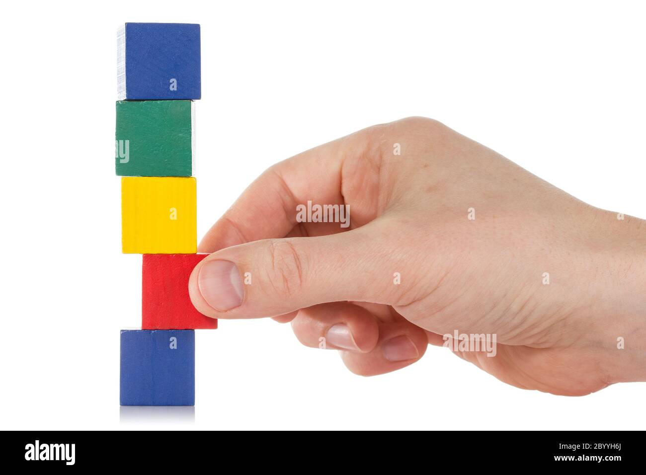 Mano stabilisce un cubo di legno Foto Stock