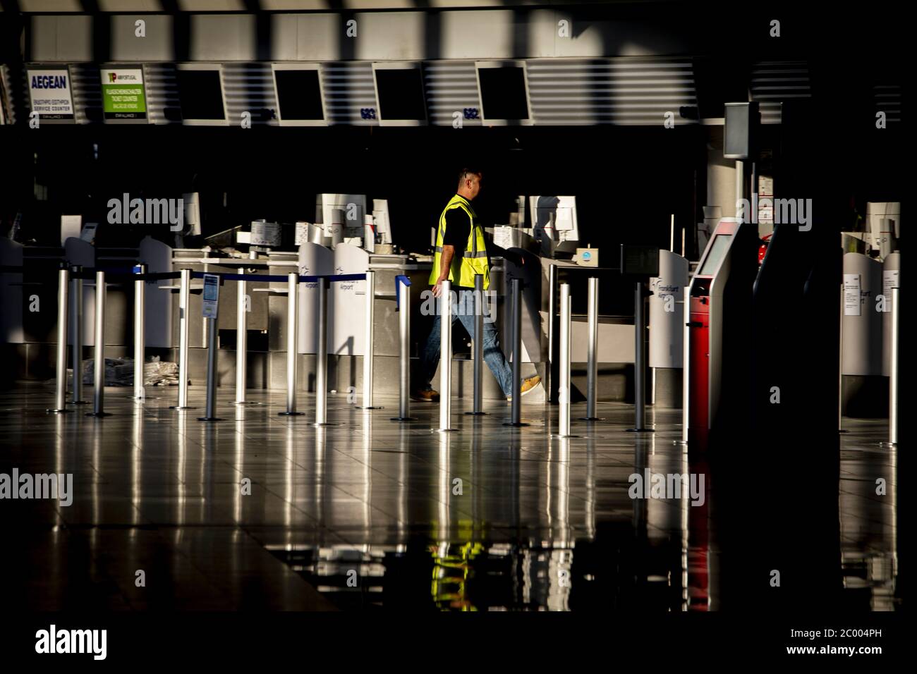 Un operaio aeroportuale nell'area di check-in presso l'aeroporto internazionale di Francoforte quasi vuoto durante il blocco causato dal virus COVID-19. In tutto il mondo, il settore del traffico aereo è fortemente influenzato dal massiccio calo del traffico. Foto Stock