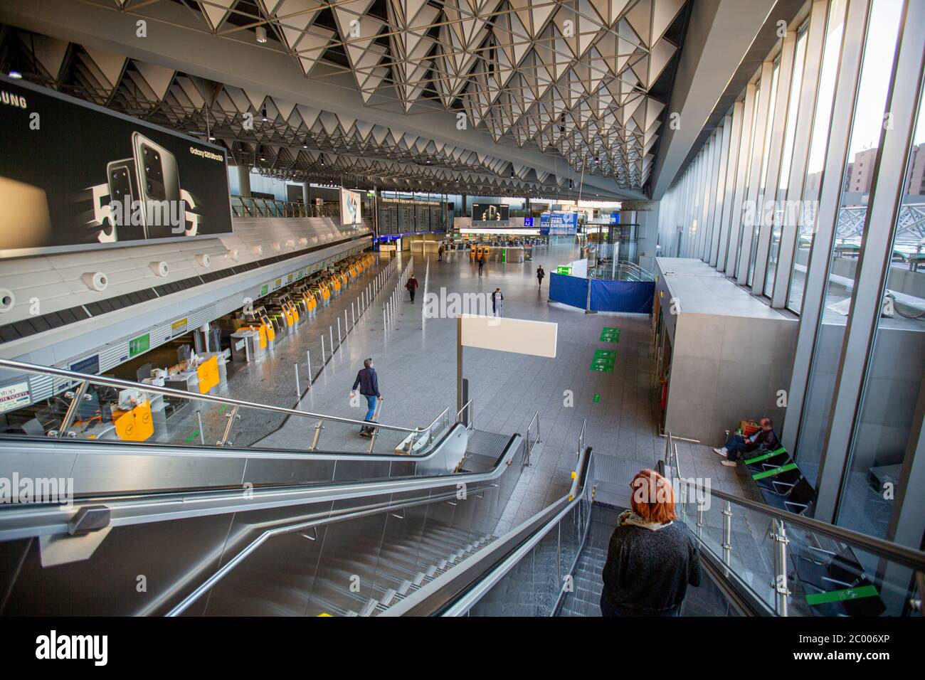 Passeggeri nell'area di check-in dell'aeroporto di Francoforte quasi vuoto durante il blocco causato dal virus COVID-19. In tutto il mondo, il settore del traffico aereo è fortemente influenzato dal massiccio calo del traffico. Foto Stock