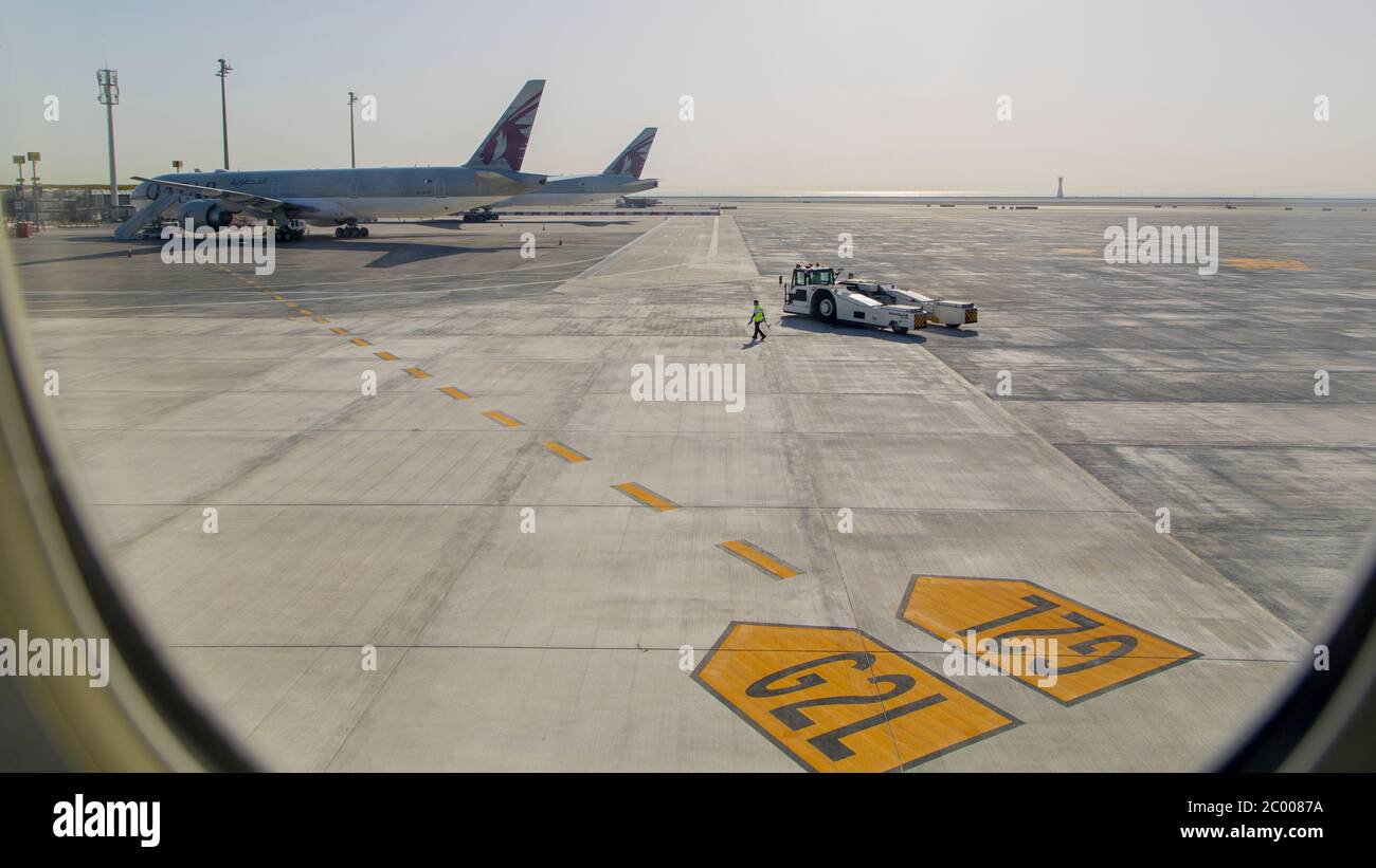 Equipaggio di terra sul asfalto presso un aeroporto internazionale di Doha quasi desertato durante il blocco causato dal virus COVID-19. In tutto il mondo, il settore del traffico aereo è fortemente influenzato dal massiccio calo del traffico. Foto Stock