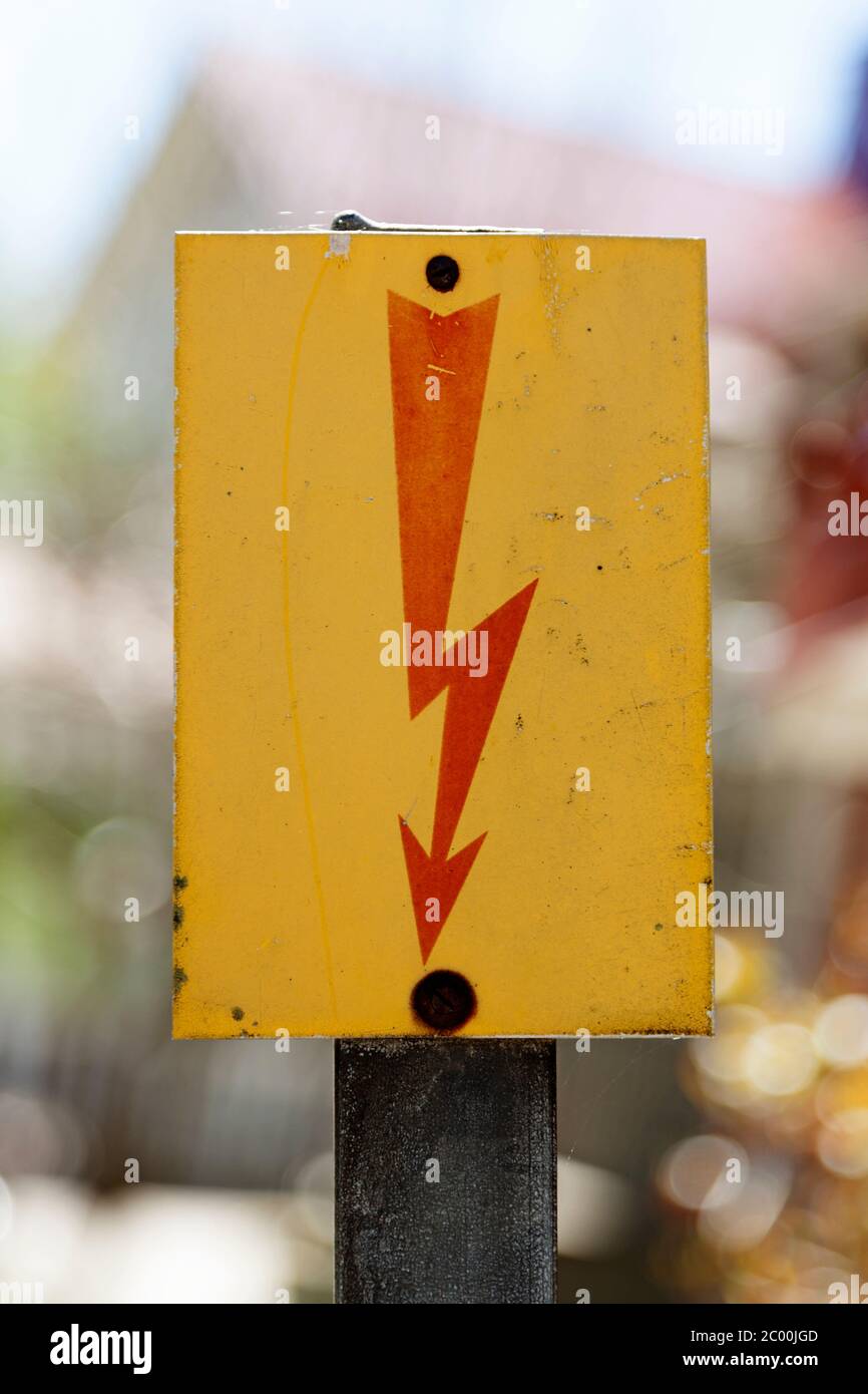 un piccolo segno giallo con un lampo rosso simboleggia una forte corrente Foto Stock