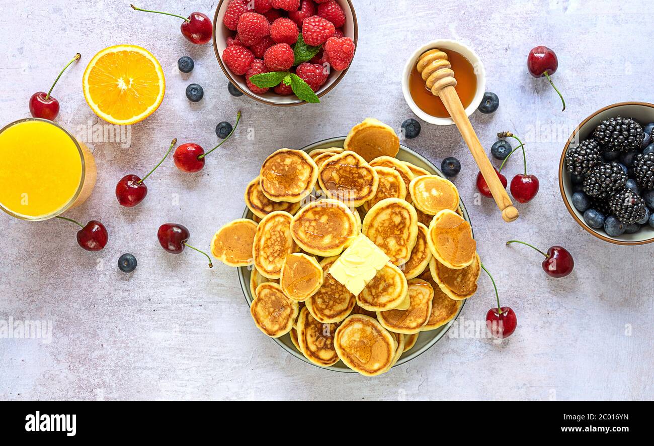 Concetto di colazione - mini pancake, burro e miele con farcitine di cereali Foto Stock