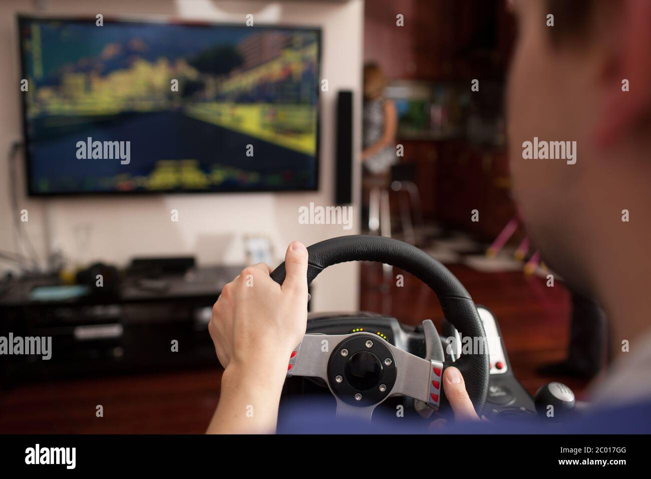 L'uomo la riproduzione di gioco di corse con volante simulator Foto Stock