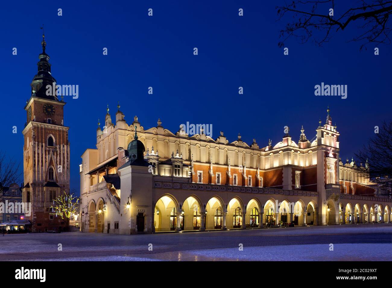Vista notturna della Torre del Municipio e dell'estremità sud-ovest della Sala dei tessuti nella piazza principale del mercato di Cracovia in Polonia. Foto Stock