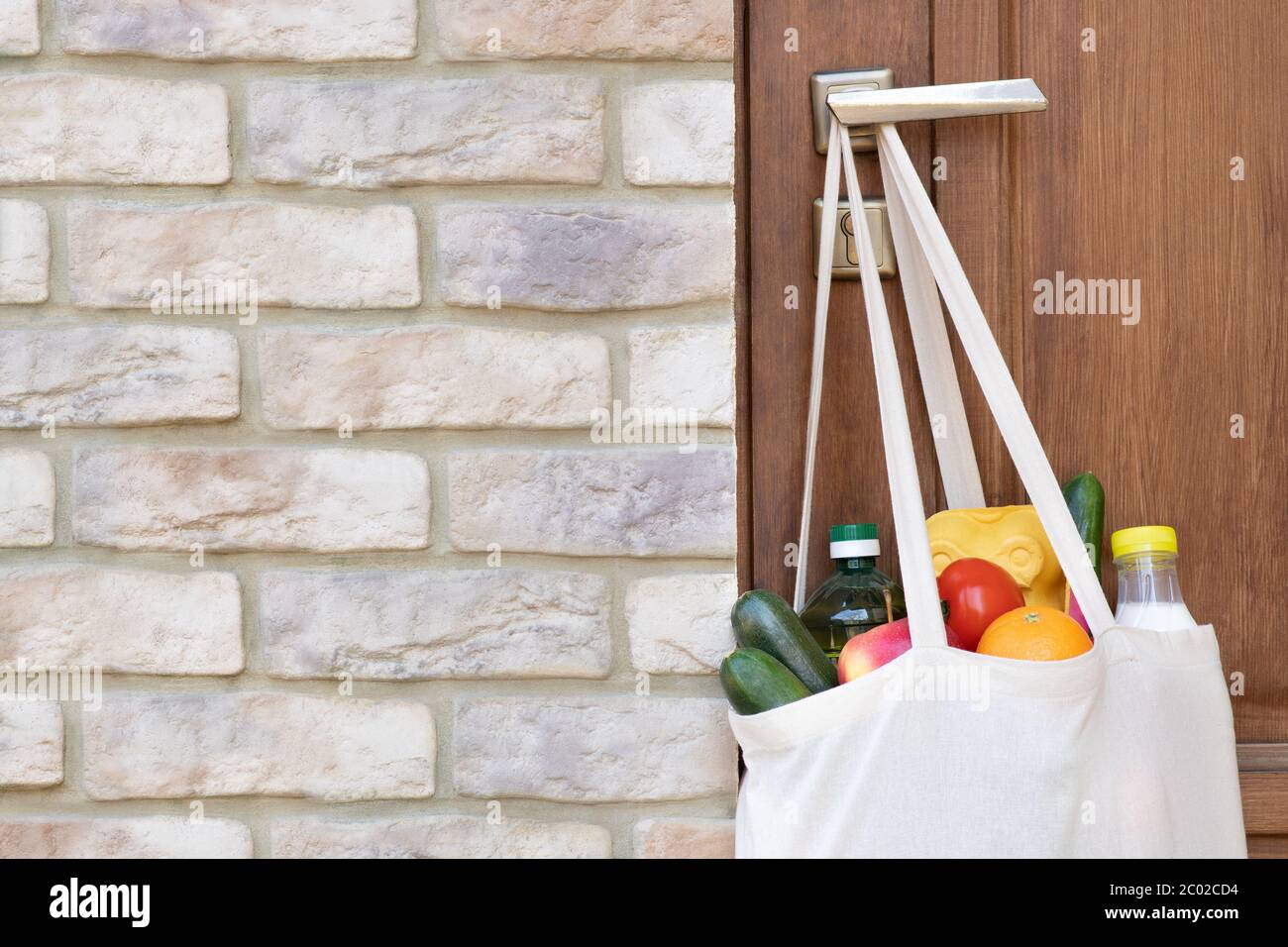 Shopping di generi alimentari in una borsa appesa alla maniglia della porta durante una quarantena Foto Stock