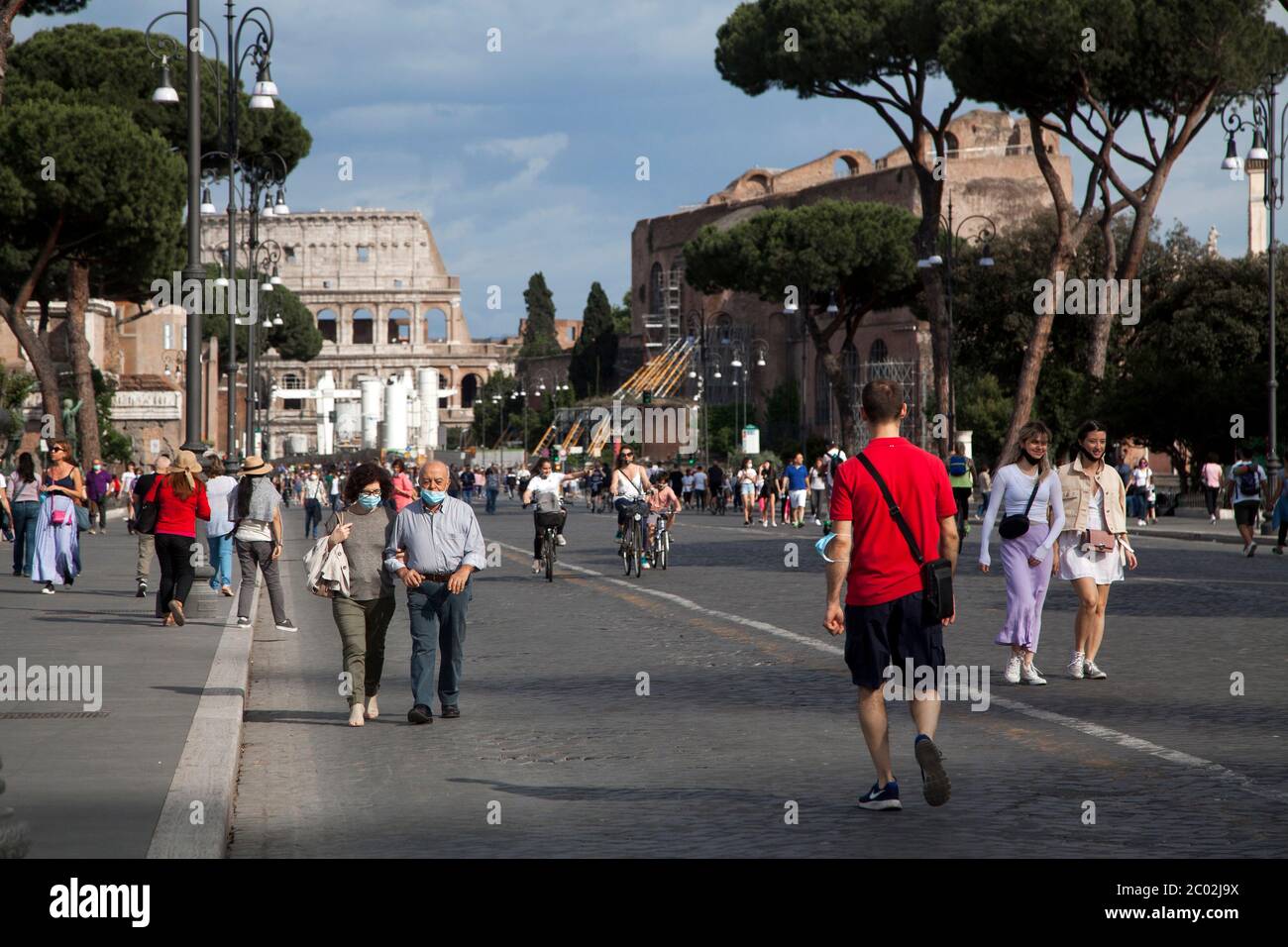 Chi indossa una maschera protettiva, cammina lungo Via dei fori Imperiali nel centro di Roma il 02 giugno 2020, mentre l'Italia inizia ad allentare la sua chiusura, durante il blocco del paese volto a frenare la diffusione dell'infezione COVID-19, causata dal novo coronavirus. Foto Stock