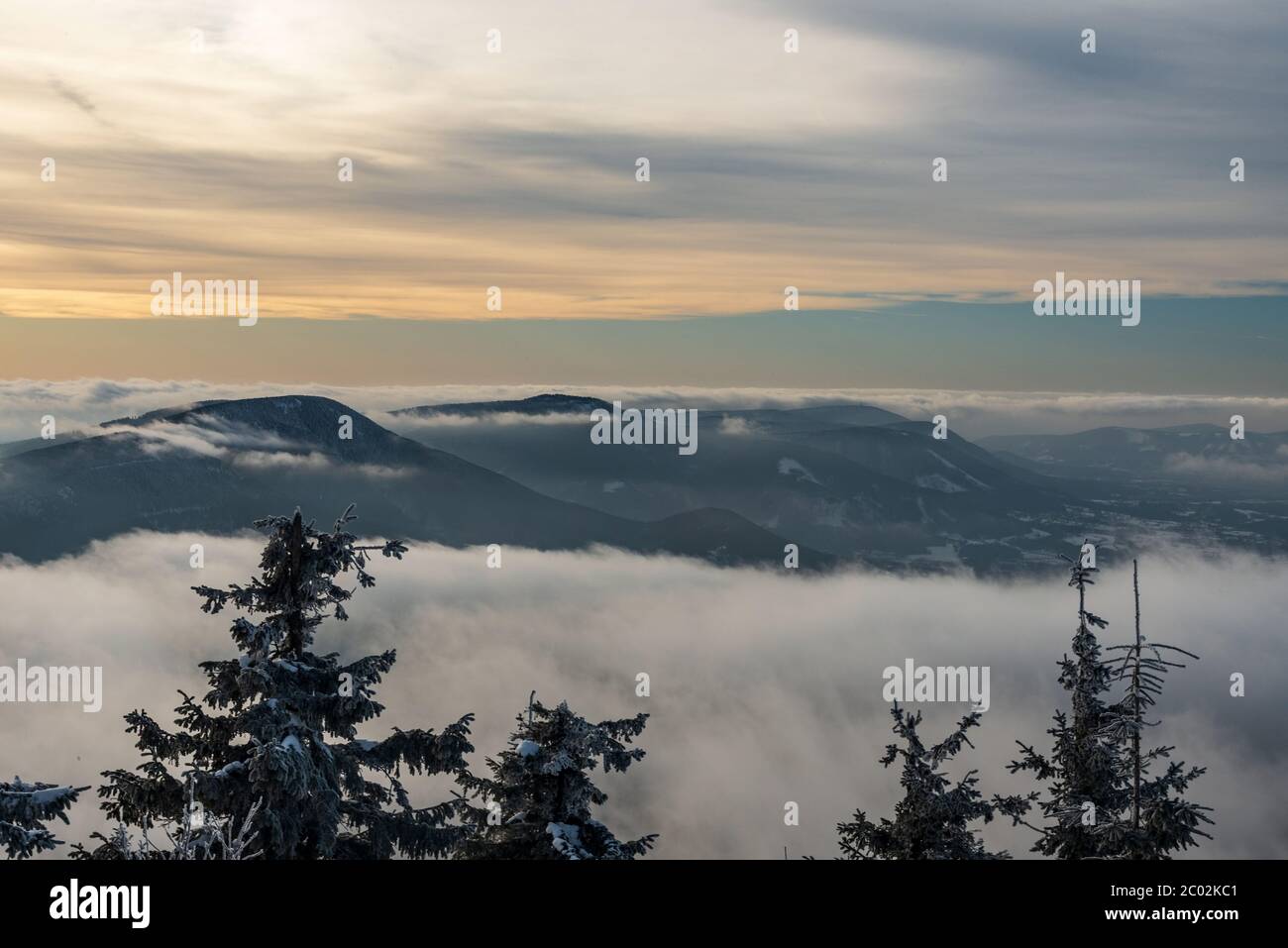 Colline di Smrk, Knehyne e Radhost dalla collina di Lysa hora in inverno Moravskoslezske Beskydy montagne nella repubblica Ceca con nebbia sulle altitudini più basse e blu Foto Stock