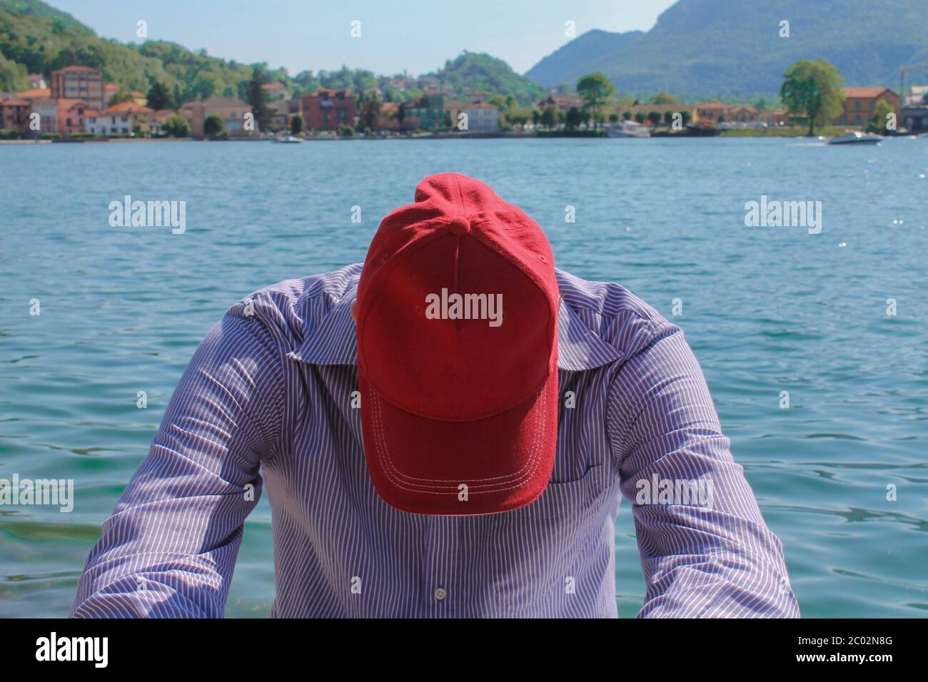 Uomo in cuffia rilassante contro il lago e le montagne Foto Stock