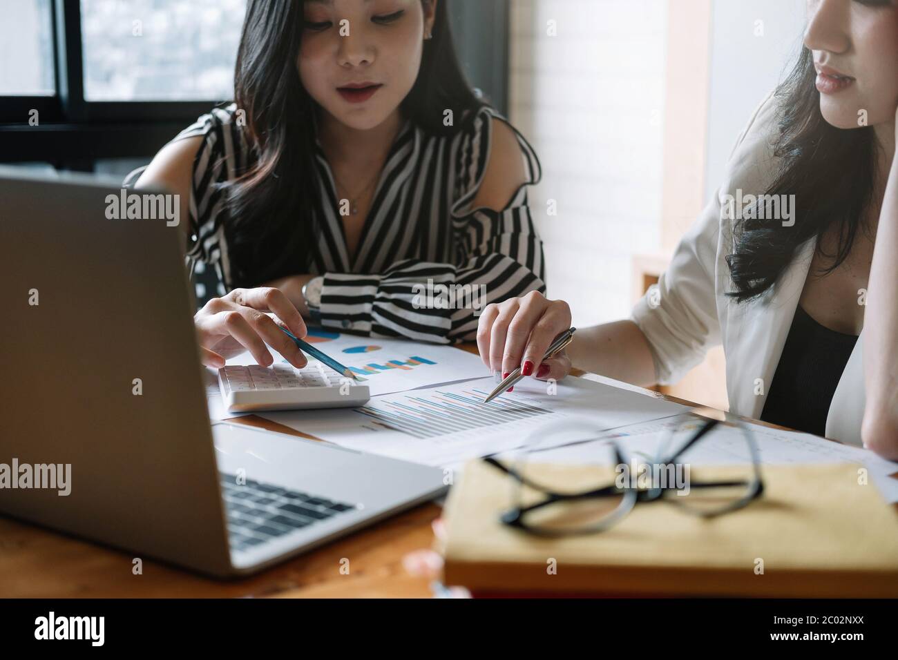 La gente di affari discutendo le tabelle e grafici che mostrano i risultati del loro lavoro di squadra di successo Foto Stock