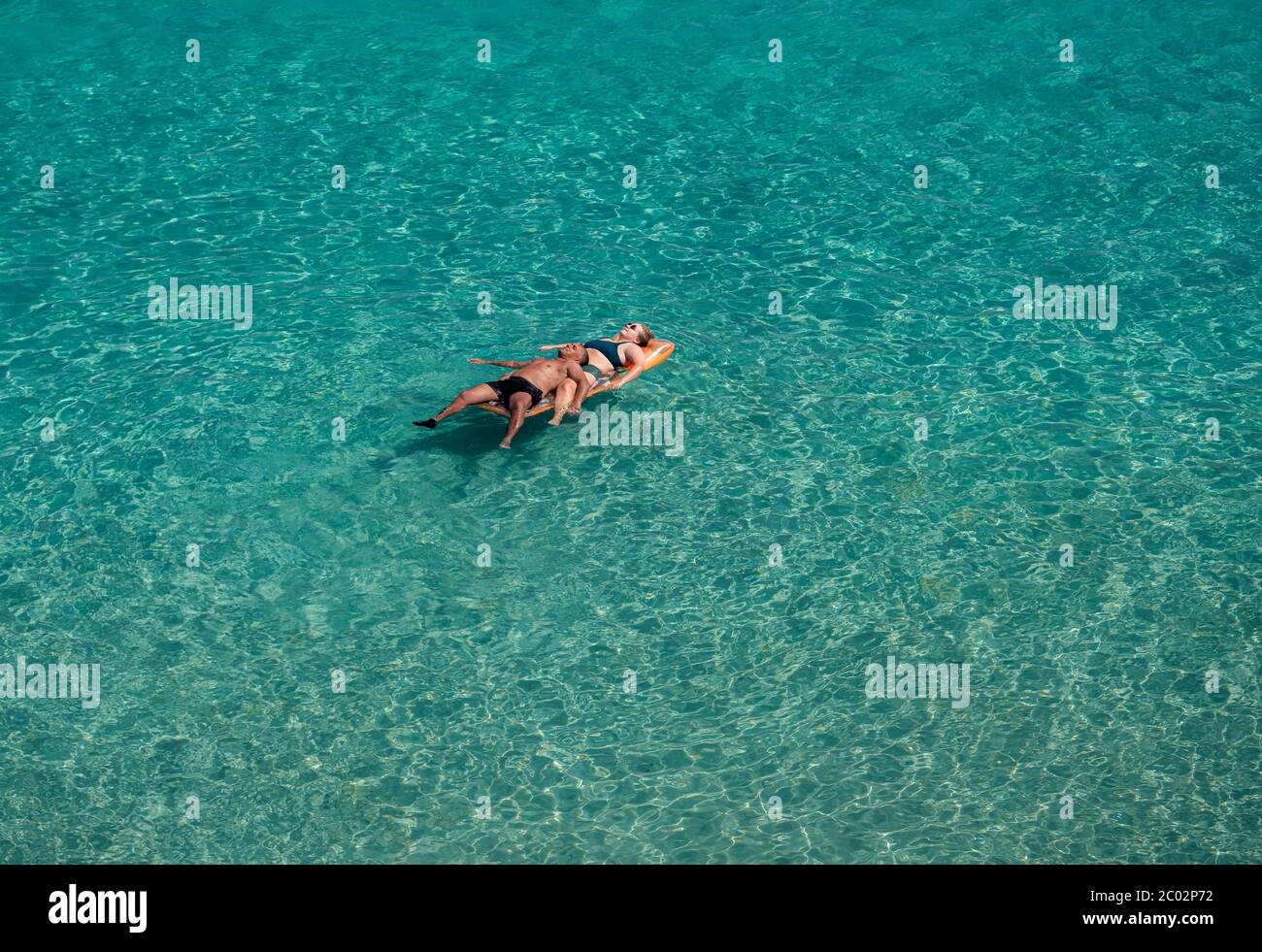 Lecce, Italia - 11 agosto 2018: Coppia di persone che galleggiano sul mare azzurro e limpido in una giornata di sole in vacanza estiva sulla costa leccese Foto Stock