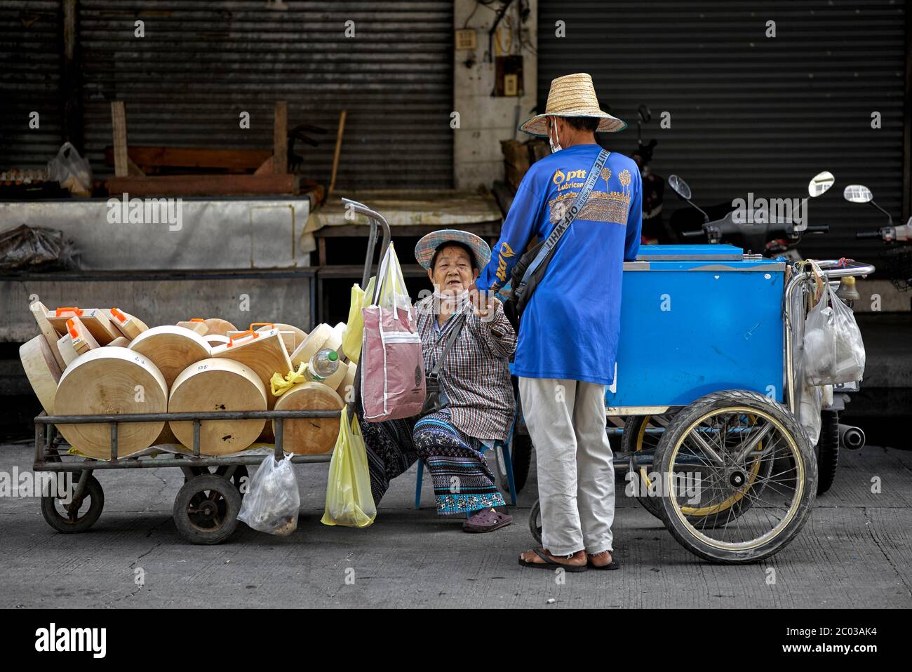 Thailandia donna anziana che lavora fornitore di strada che vende tagliere di legno. Thailandia Sud-est asiatico Foto Stock