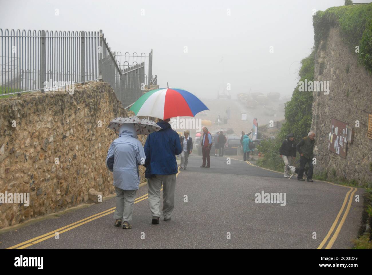 I visitatori del mare in una giornata umida e nebbiosa, birra, Devon, Inghilterra Foto Stock