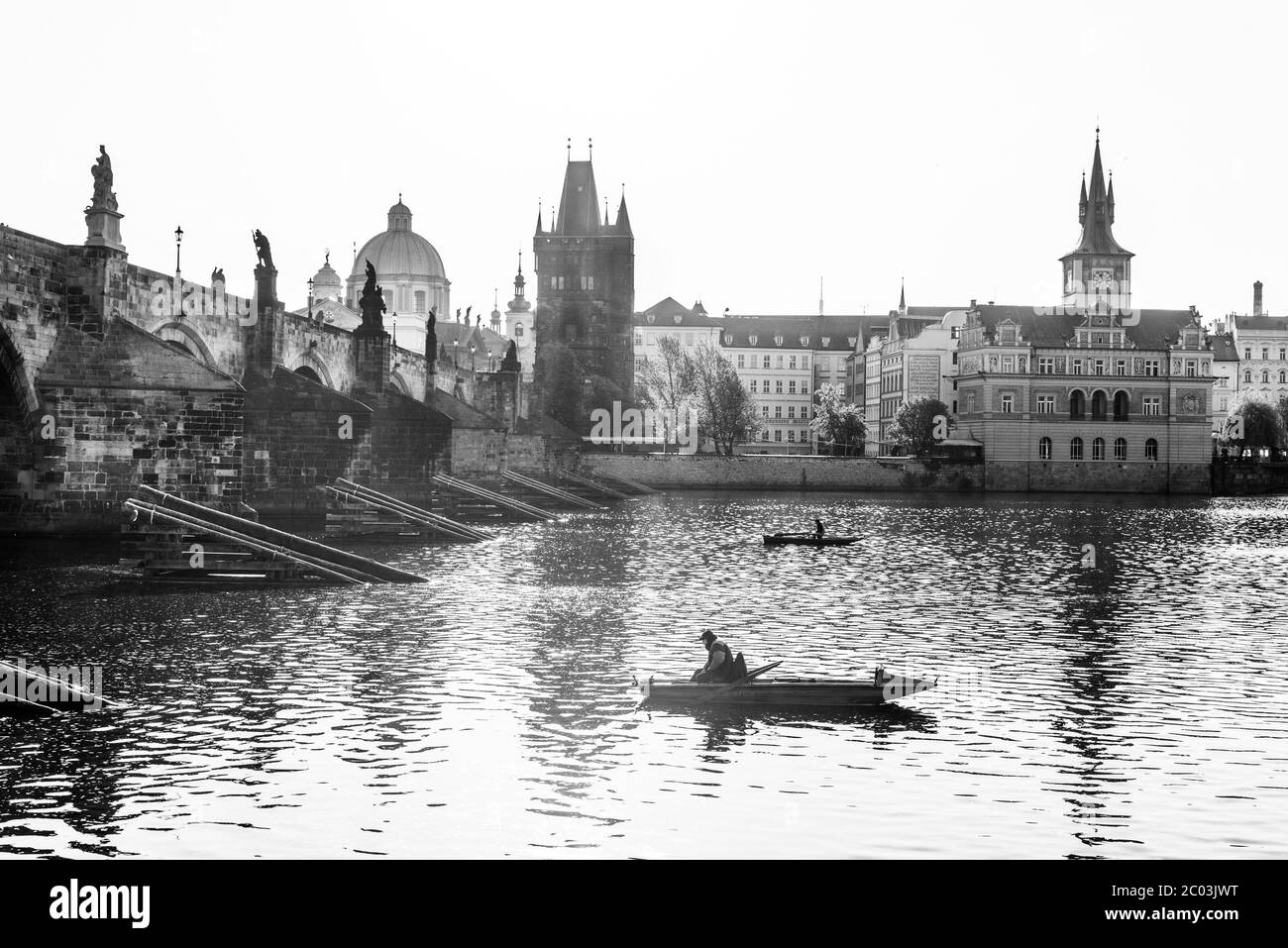 Pesca sotto il Ponte Carlo, ceco: Karluv Most. Mattina soleggiata sul fiume Moldava. Praga, Repubblica Ceca. Immagine in bianco e nero. Foto Stock