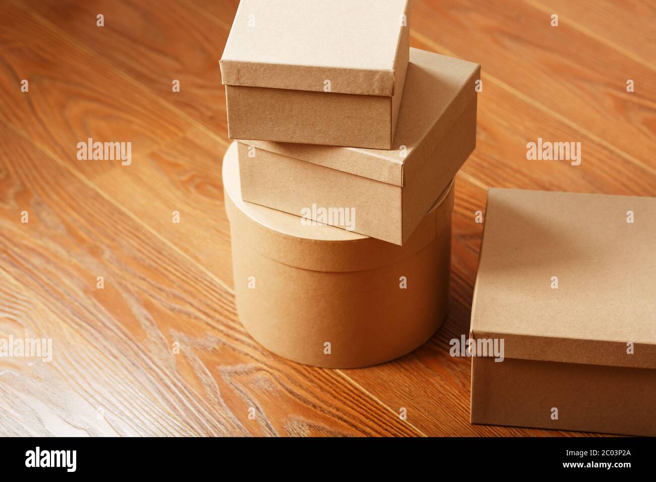 Scatole di cartoni sul pavimento in legno di forme diverse. Foto Stock