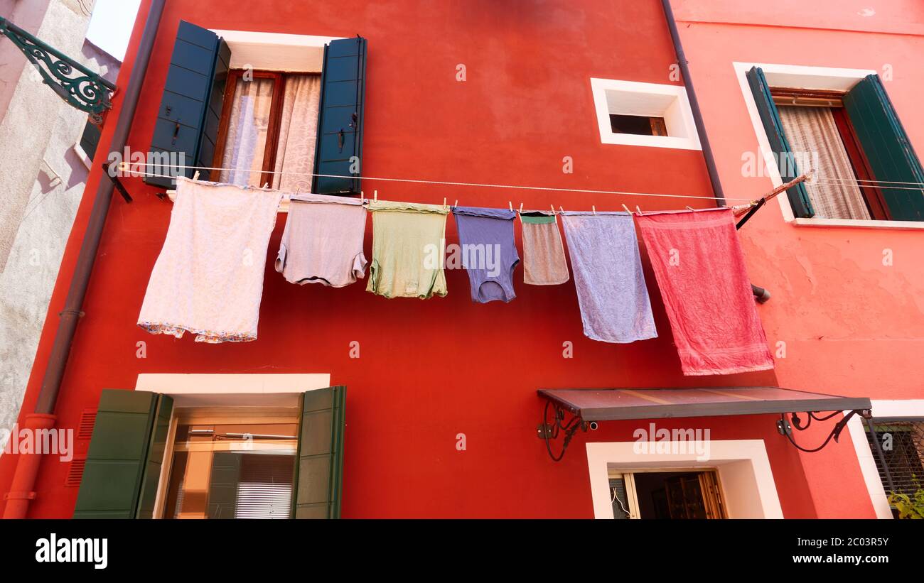 Angolo di muro di vecchia casa veneziana con abiti asciuganti sulla corda fuori, Venezia, Italia Foto Stock