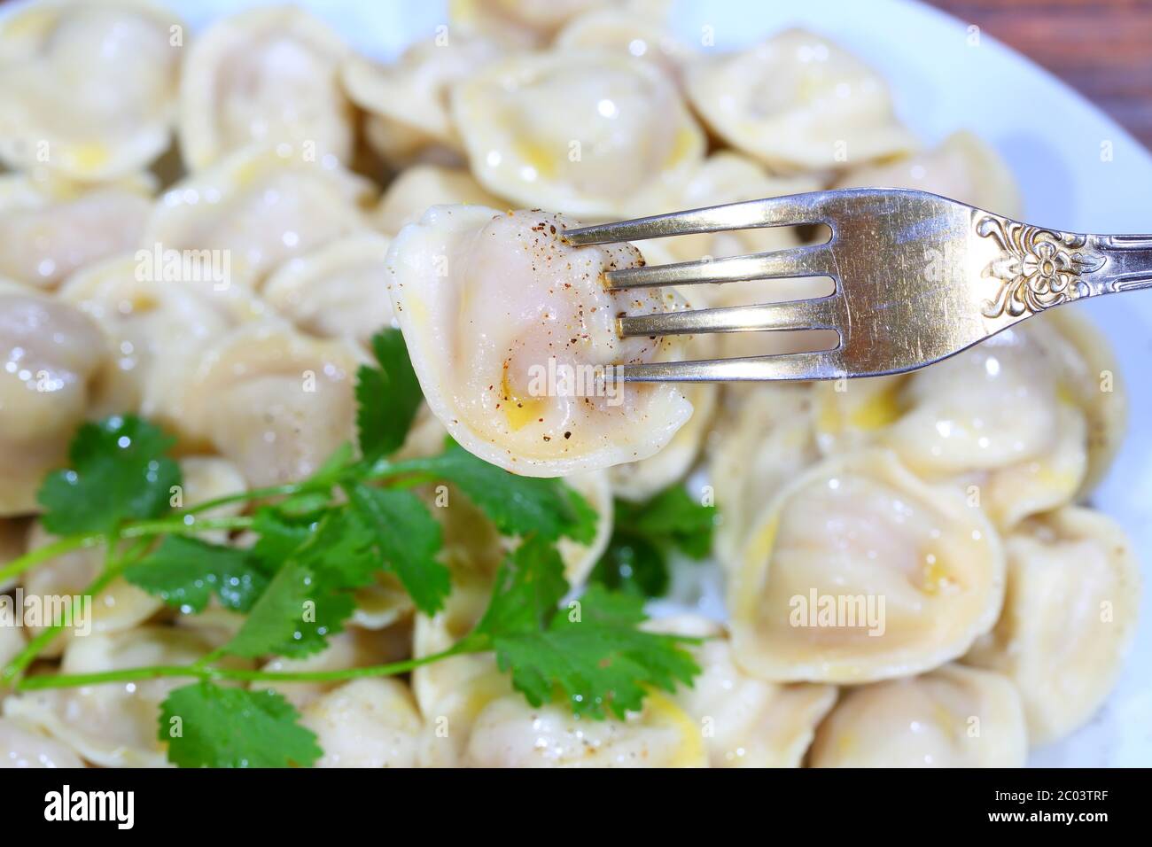 Pelmeni con panna acida, burro macinato al pepe e prezzemolo fresco Foto Stock