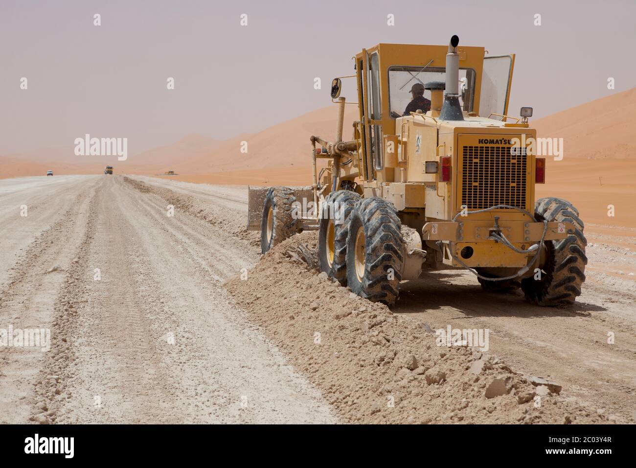 Un livellatore che viene guidato su gesso per fare una nuova strada, parte dei lavori per costruire un grande impianto petrolifero nel deserto del Sahara. Foto Stock