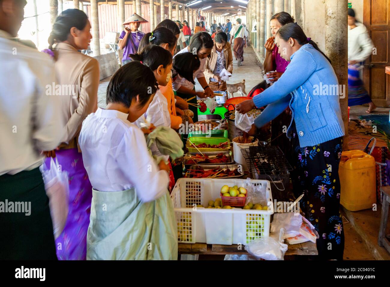 Adolescenti locali che acquistano sacchi a una stalla nel mercato Thaung Thut, lago Inle, Shan state, Myanmar. Foto Stock
