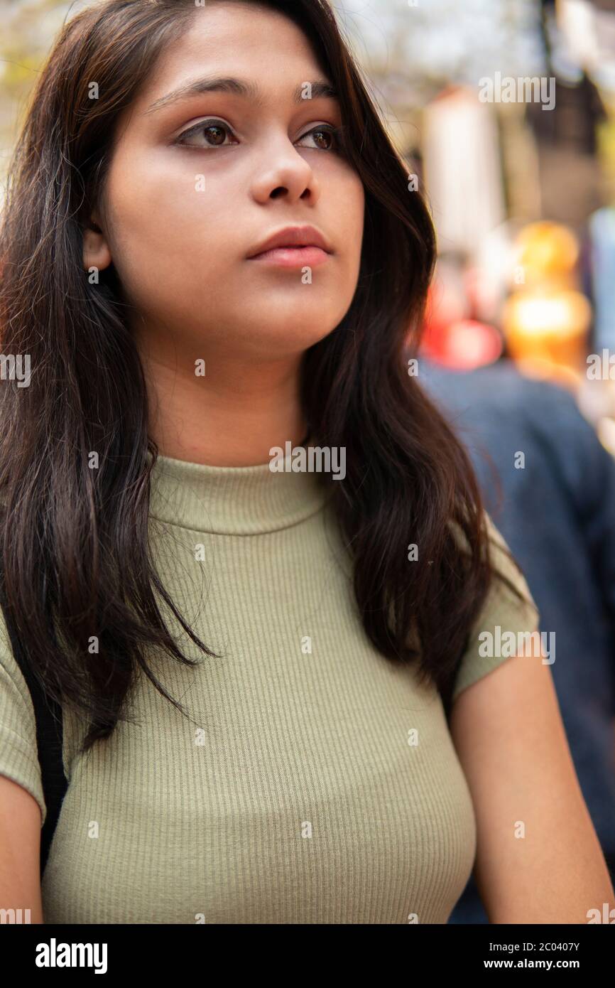 Serena ragazza teen in piedi al mercato e pensando con espressione vuota. Foto Stock