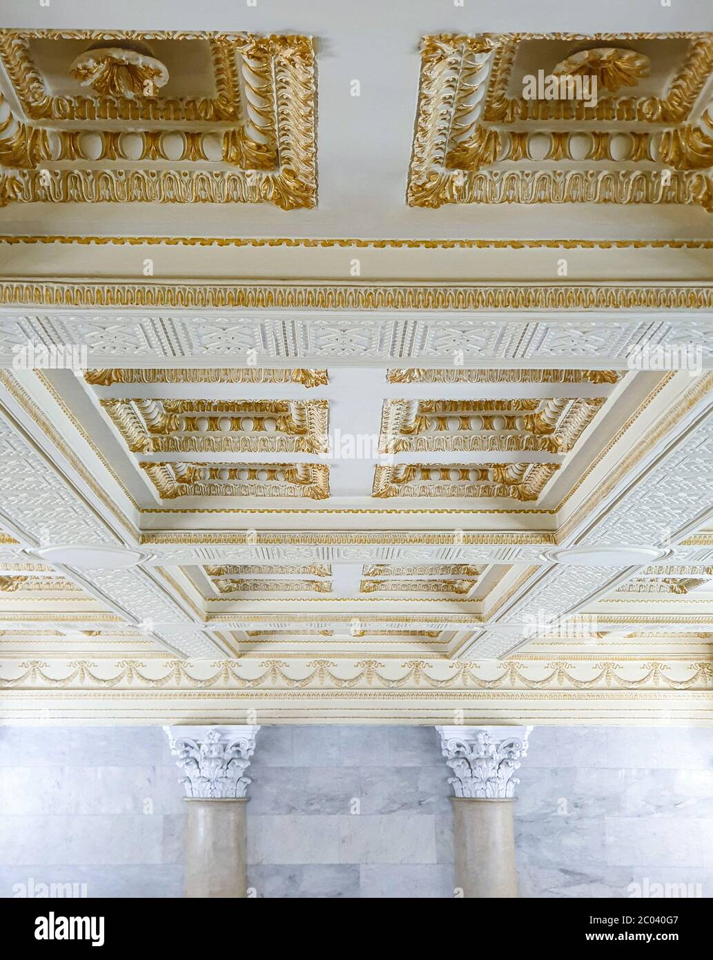 Soffitto lungo in gesso dorato con modanature in gesso. Foto Stock