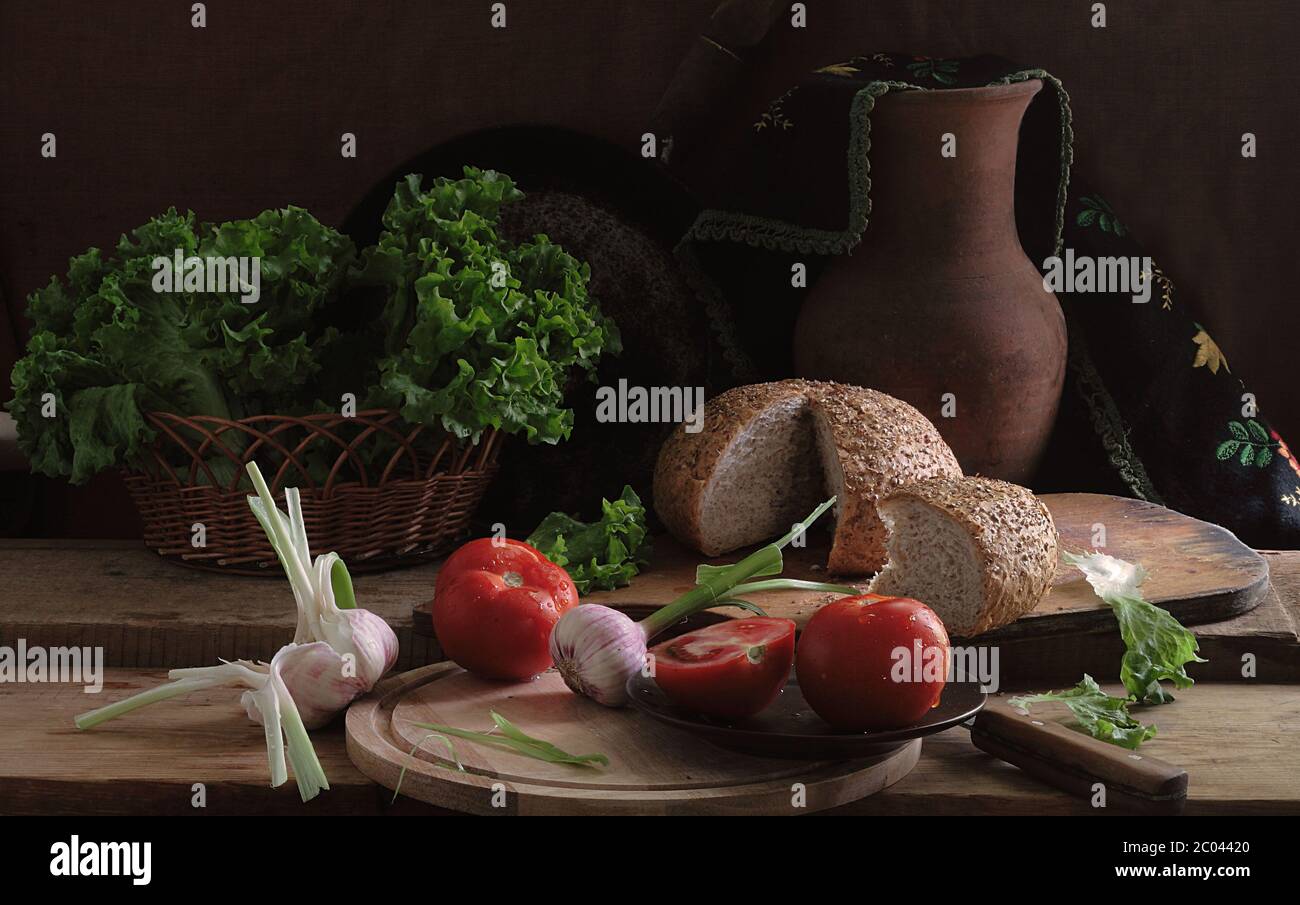 Pomodori, aglio, pane e foglie di insalata verde Foto Stock Pomodori, aglio, pane e foglie di insalata verde Foto Stock