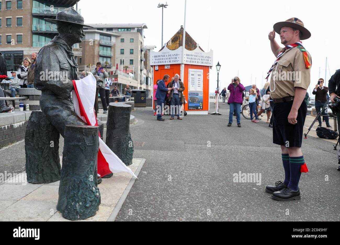 Rover Scout Matthew Trott saluta una statua di Robert Baden-Powell su Poole Quay nel Dorset prima della sua attesa rimozione in 'sicuro deposito' a seguito di preoccupazioni circa le sue azioni mentre in militare e 'nazisti simpatie '. L'azione segue una serie di proteste sulla materia Black Lives in tutto il Regno Unito, scatenate dalla morte di George Floyd, ucciso il 25 maggio mentre era in custodia di polizia nella città americana di Minneapolis. Foto Stock