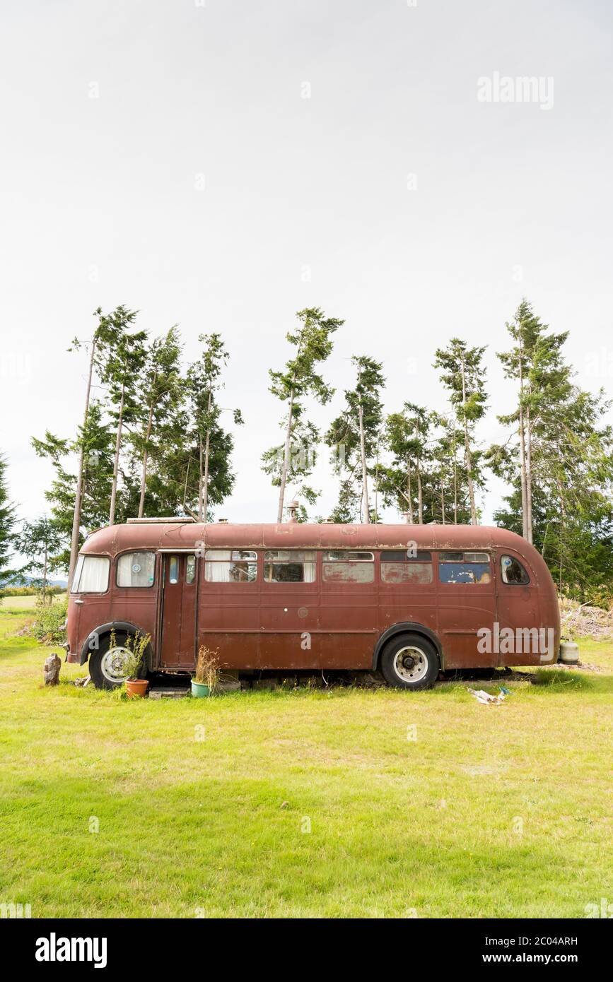 Un vecchio autobus o pullman ford arrugginendo su un campeggio a Manapouri Nuova Zelanda Foto Stock