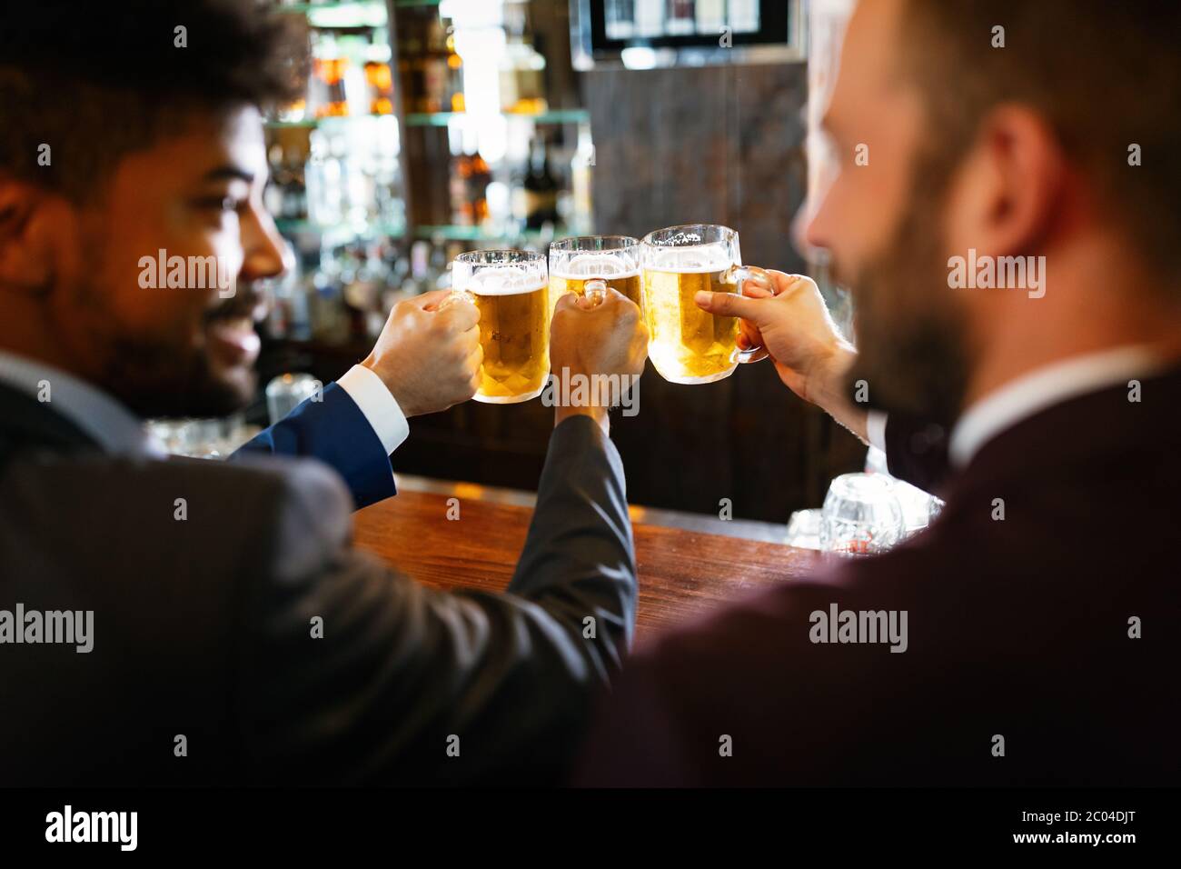 Persone, uomini, tempo libero, amicizia e celebrazione concetto. Amici maschi felici che bevono birra al pub Foto Stock
