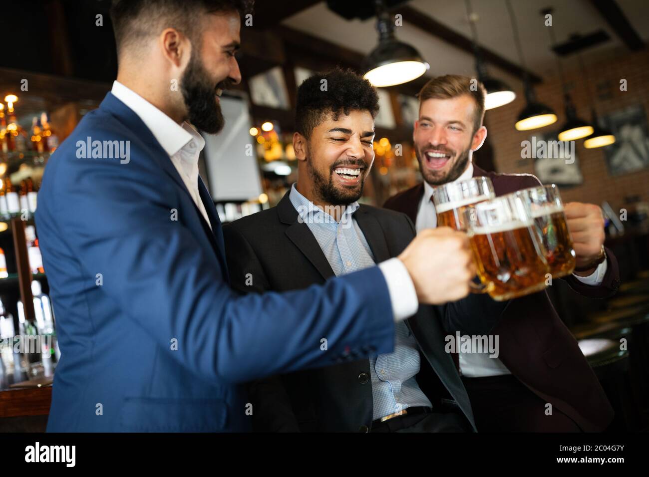 Persone, uomini, tempo libero, amicizia e celebrazione concetto. Amici maschi felici che bevono birra al pub Foto Stock