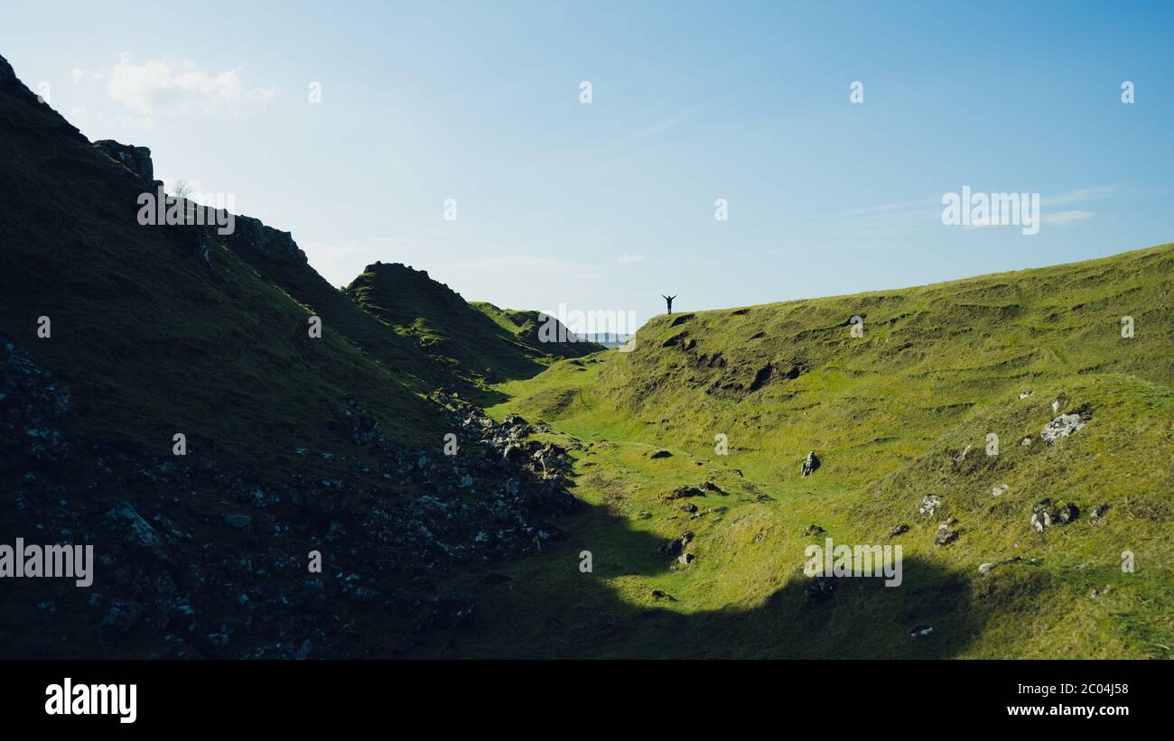 Lone uomo si erge sulla cima del tumulo, che domina le colonne di pietra, le forme e cerchi sottostanti. Foto scattata a Fairy Glen, nell'isola di Skye, Scozia. Foto Stock