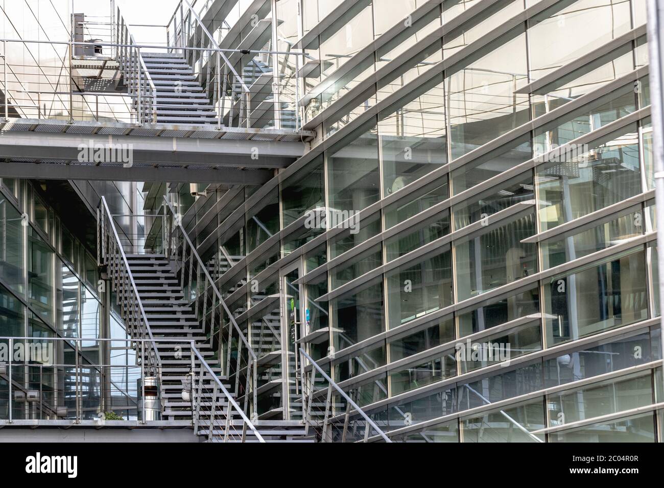 Un frammento di un moderno edificio aziendale e una scalinata esterna. La struttura è realizzata in vetro e calcestruzzo. Foto Stock Un frammento di un moderno edificio aziendale e una scalinata esterna. La struttura è realizzata in vetro e calcestruzzo. Foto Stock