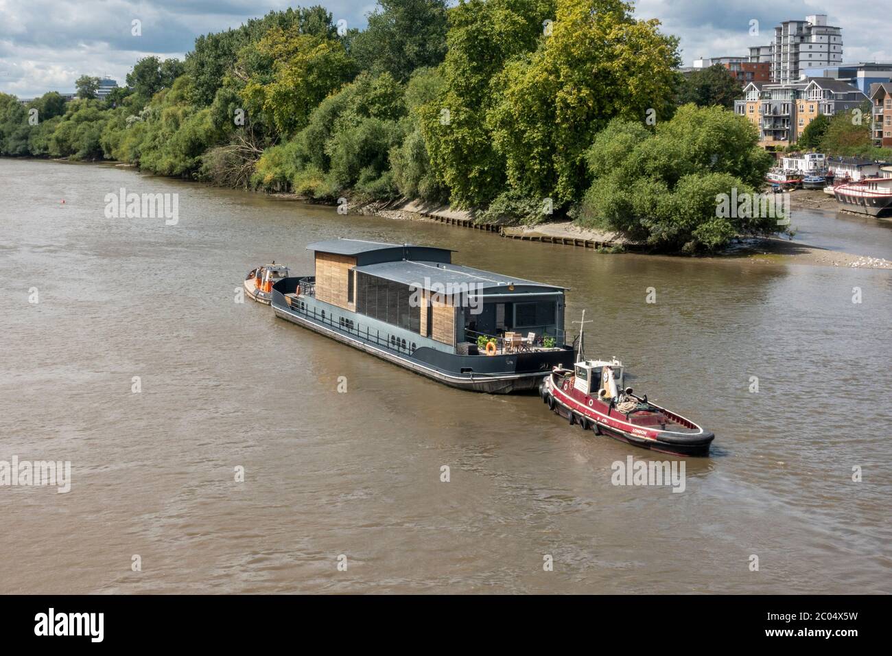 Una barca di casa di fiume che è spostata lungo il Tamigi a Richmond upon Thames, Surrey, Inghilterra, Regno Unito. Foto Stock