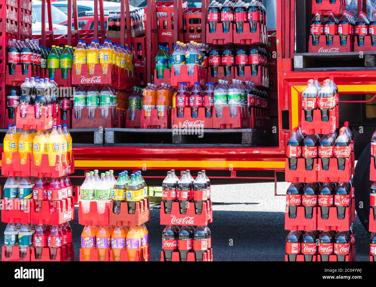Bottiglie di bevanda fresca di marca Coca cola in casse su un camion e in strada in Sud Africa Foto Stock