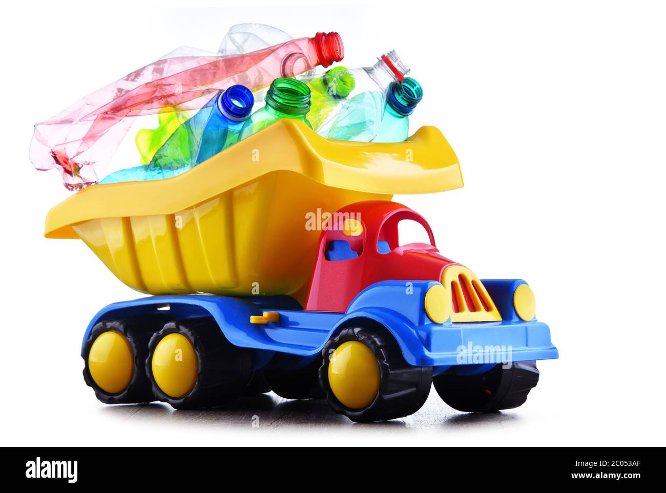 Carrello giocattolo colorato in plastica caricato con bottiglie in plastica isolate su bianco. Foto Stock Carrello giocattolo colorato in plastica caricato con bottiglie in plastica isolate su bianco. Foto Stock