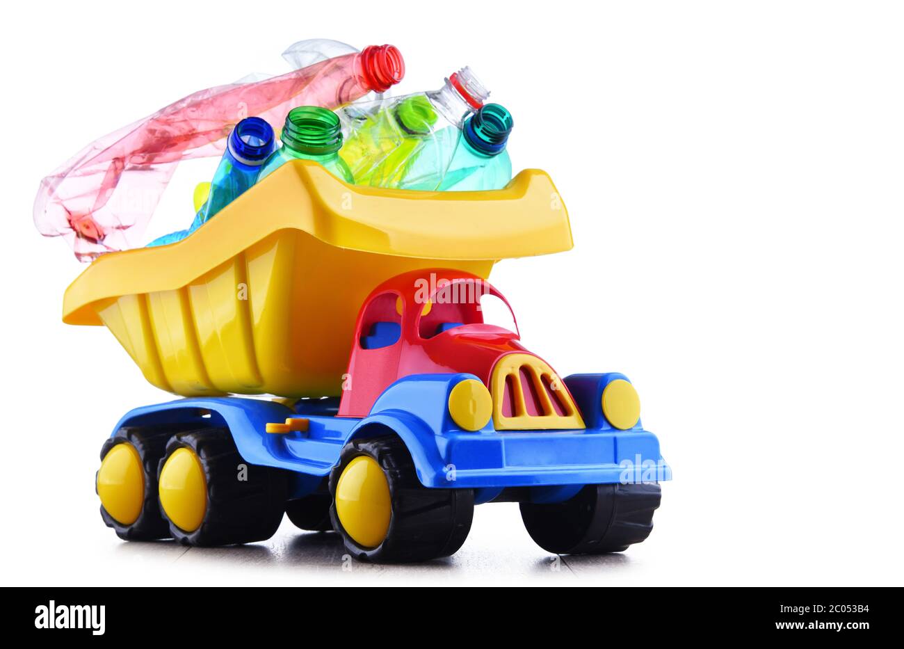 Carrello giocattolo colorato in plastica caricato con bottiglie in plastica isolate su bianco. Foto Stock Carrello giocattolo colorato in plastica caricato con bottiglie in plastica isolate su bianco. Foto Stock