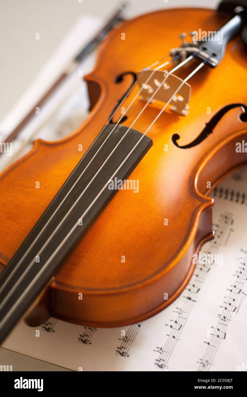 Primo piano del violino appoggiato sulla spartiti. Strumenti a corda. Concetto di musica classica. Foto Stock