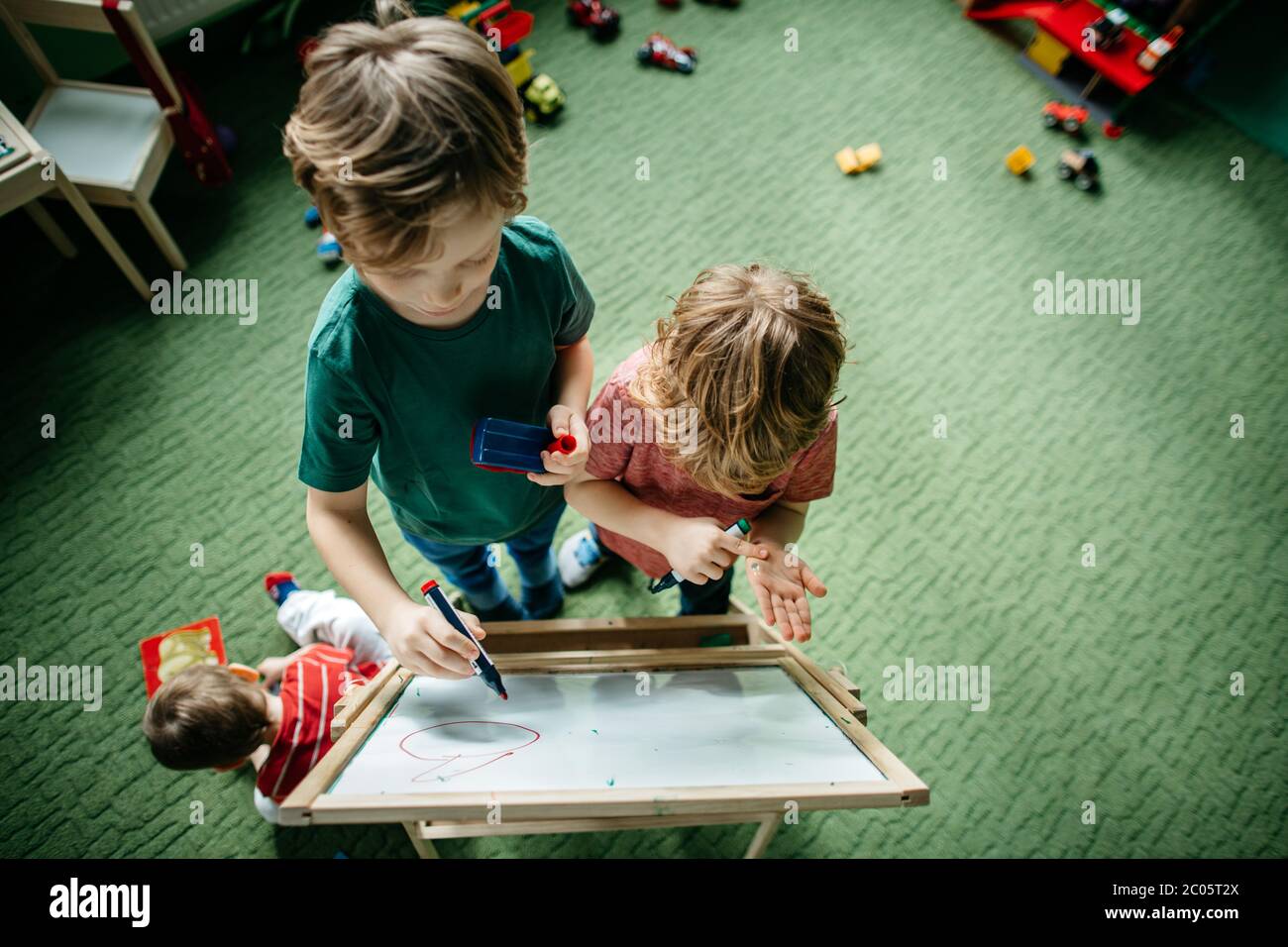Vista dall'alto dei bambini che scrivono su una tavola da disegno Foto Stock