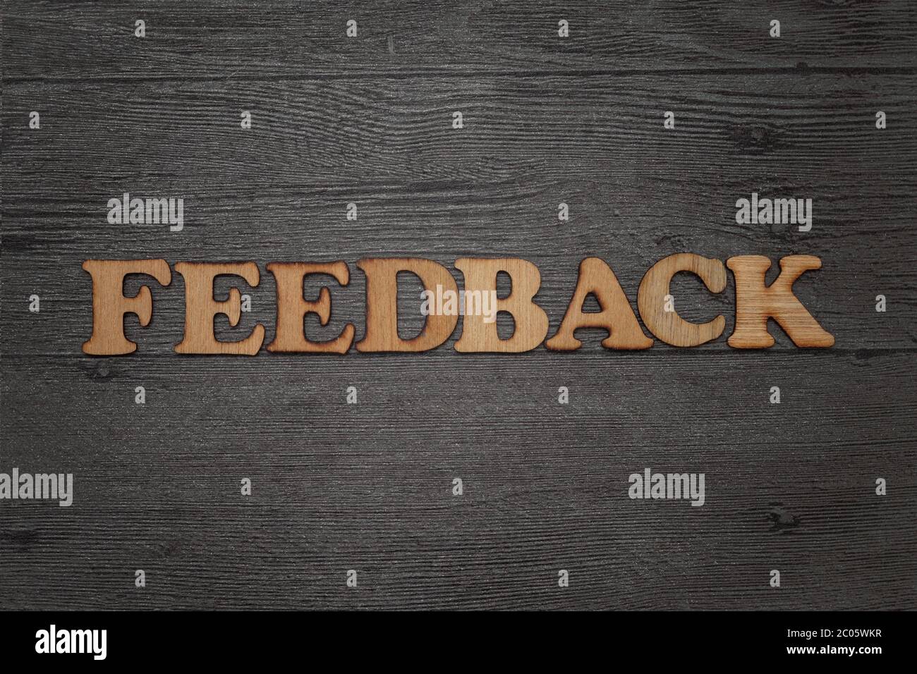 Parola di feedback, ordinata in alfabeto ligneo, su sfondo scuro grunge Foto Stock